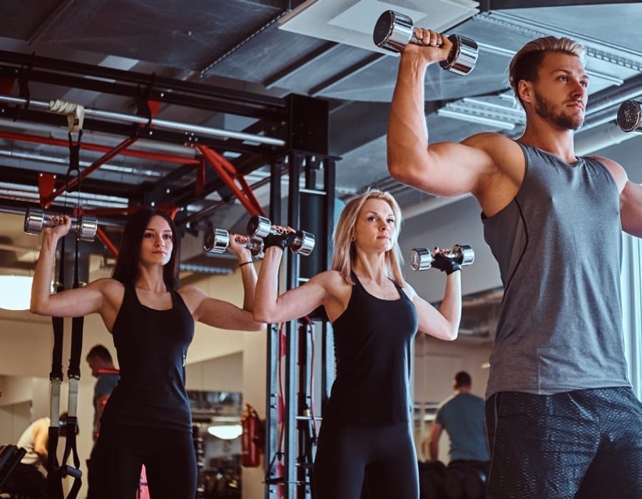 Athletes performing a dumbbell shoulder press