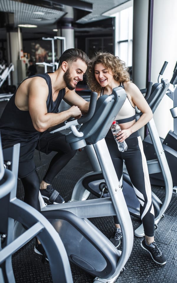 Coach assisting a member during a machine workout